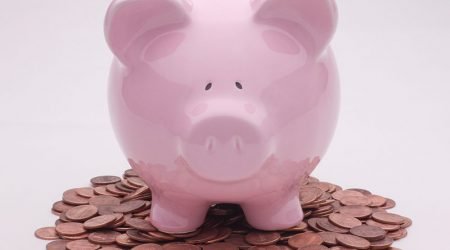 Piggy bank sitting on a pile of pennies