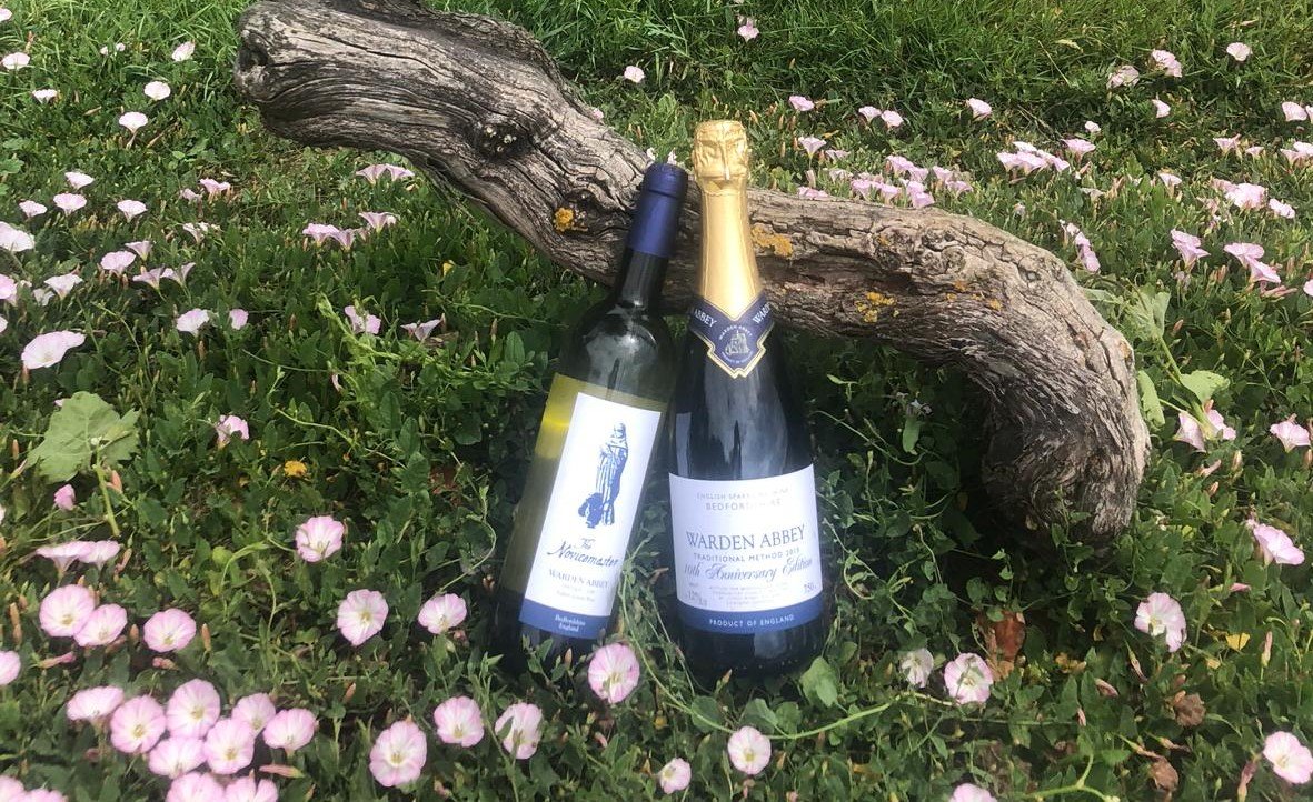 Two bottles of Warden Abbey Vineyard wine sitting in wildflowers
