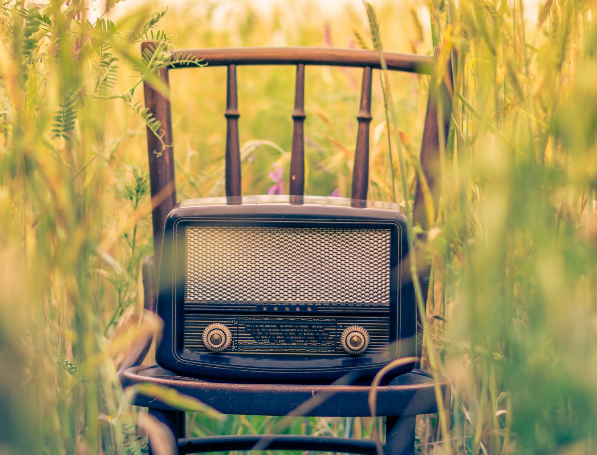 Old fashioned radio on a chair in a field