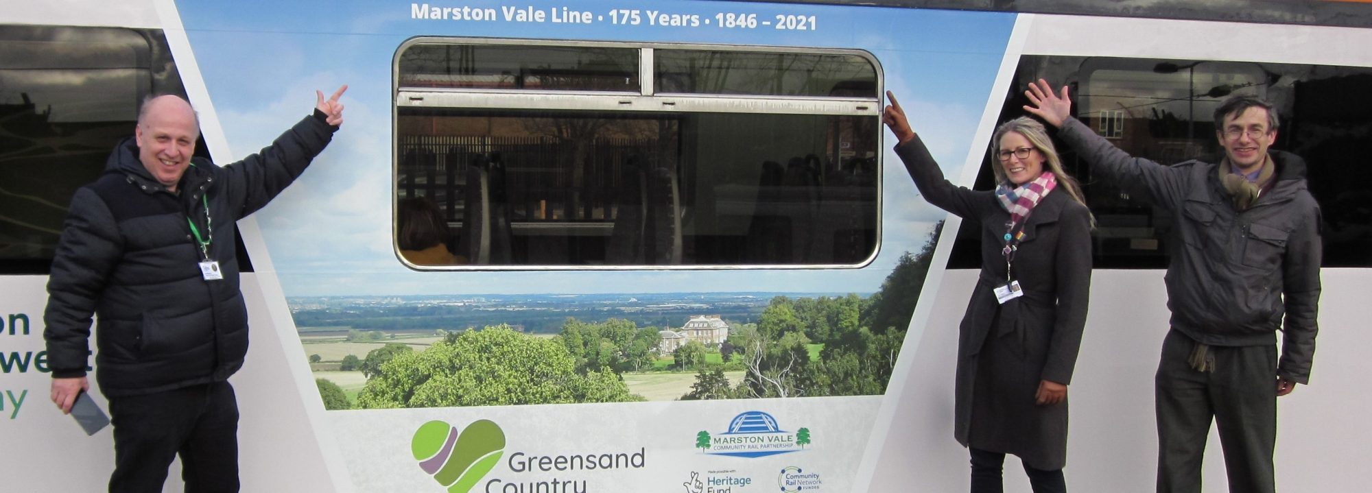 3 people pointing at new train wraps